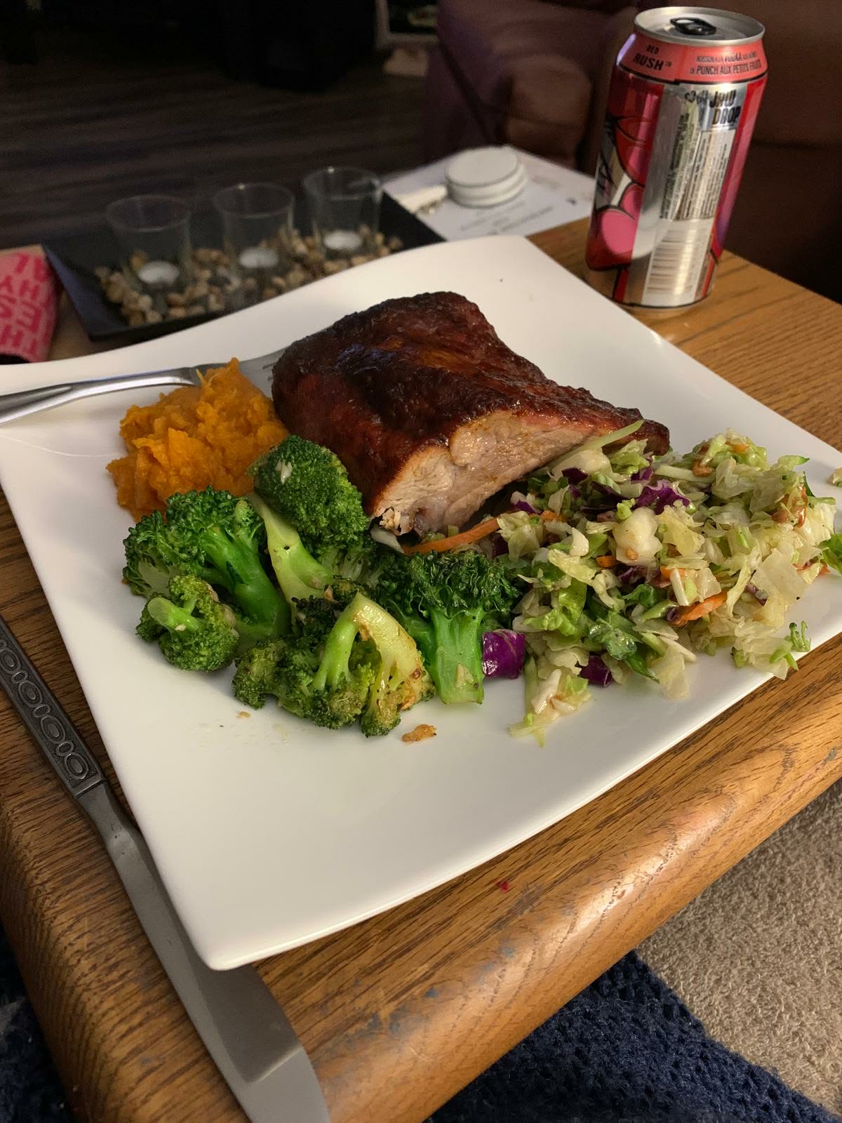 Glazed barbecue ribs with mashed sweet potato, broccoli and cabbage slaw on a white square plate